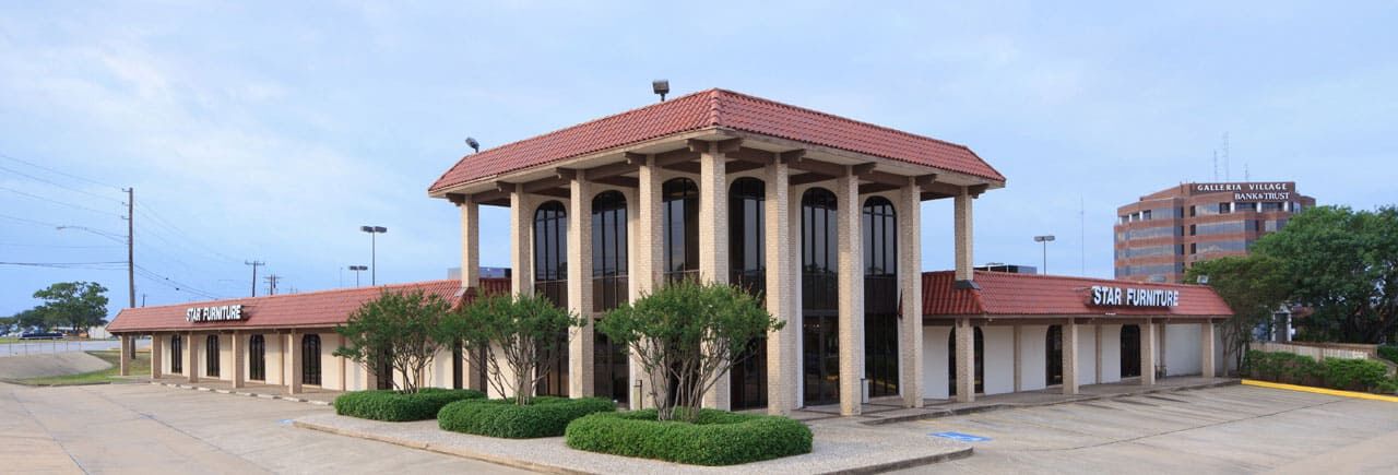 a building with columns and a parking lot
